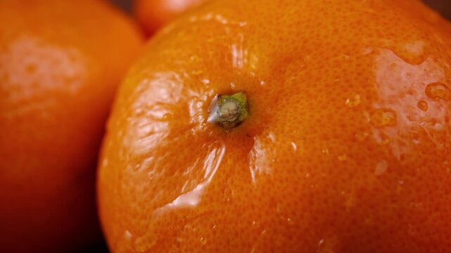 Oranges with droplets of water slowly dripping over their peel emphasize their freshness, natural flavor
