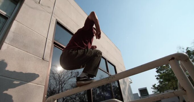 Incredible parkour technique in 1000fps slow motion. Skilled traceur executes perfect tic-tac to precision jump, landing with balance on a narrow railing. Concept: skill, precision, technique, balance