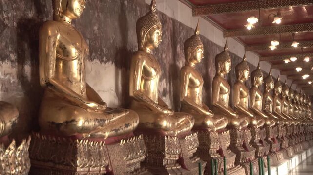 Row of ancient buddha statues in buddhist temple