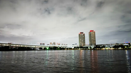 Fototapeta premium Modern Waterfront Skyline with Illuminated High-Rise Buildings at Night