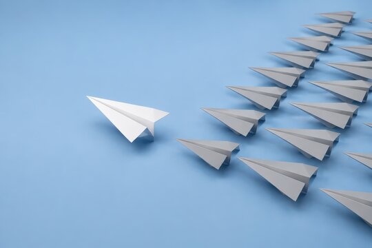 White paper plane leading rows of grey paper planes