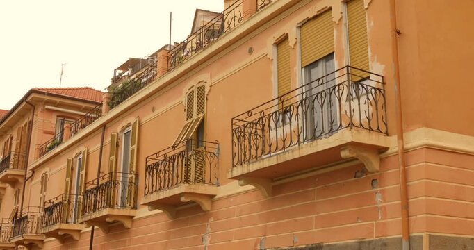Historic residential facade in Imperia old town with ornate balconies, warm Mediterranean colors and traditional Italian architecture on the Ligurian Riviera.