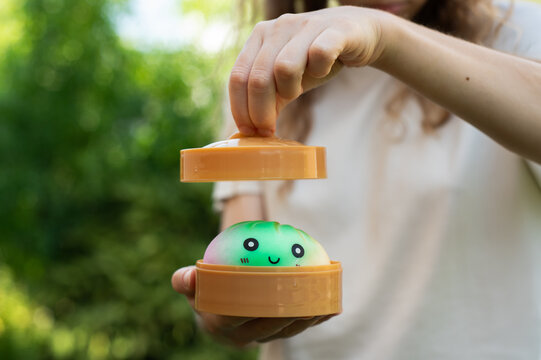 Hand lifting the lid of a bamboo steamer to reveal a kawaii dumpling toy.