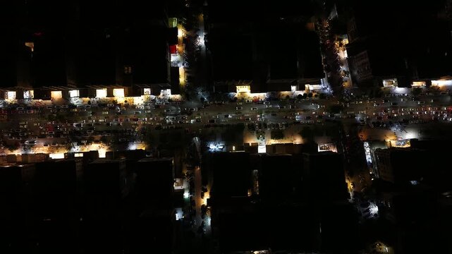Aerial night view of an urban landscape in Syria featuring glowing city lights and illuminated streets.  Post-war Syrian cityscape and daily life at night.