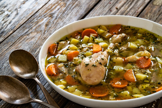 Krupnik - polish barley soup with chicken meat on wooden table
