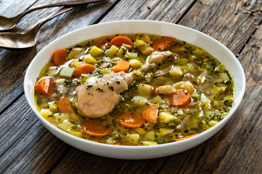 Krupnik - polish barley soup with chicken meat on wooden table
