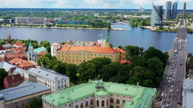 Riga Castle stands beside Daugava with historic towers and modern skyline beyond