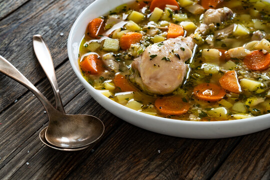 Krupnik - polish barley soup with chicken meat on wooden table
