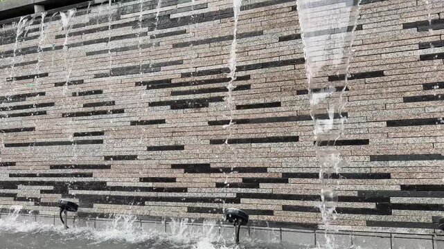 Heavy Water Streams Cascading Down Textured Stone Fountain Wall