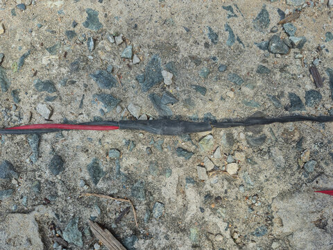 Electrical Cable Wire Splicing with Black Shrink Tube Insulation on Rough Concrete Surface for Power Connection Repair