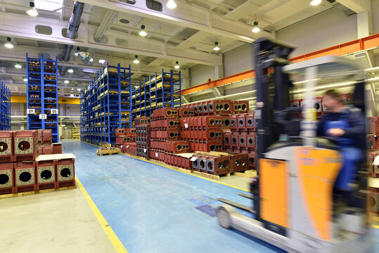 forklift and high shelves with industrial goods in a goods warehouse of a factory