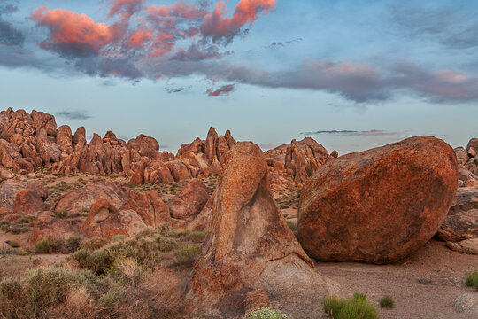Beautiful wide view of rock formations in Alabama Hills under pink sunset clouds