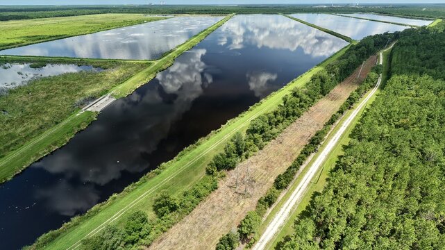 Aerial view of Georgia-Pacific Palatka Operations featuring industrial wastewater treatment ponds reflecting clouds, surrounded by forests in Palatka, Florida, United States.