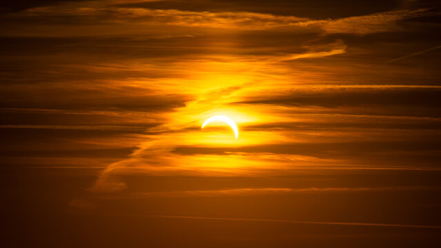 Eine partielle Sonnenfinsternis hinter sanften Schleierwolken