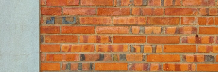 Building wall section showing red brick masonry alongside rough plastered surface © Harry