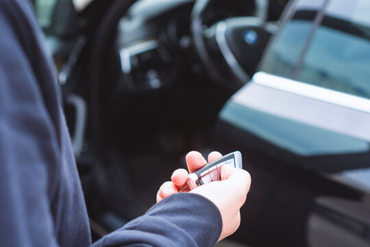 Close up of a person holding a car key inside a modern vehicle, representing driving, car ownership, automotive technology, transportation and everyday mobility lifestyle.