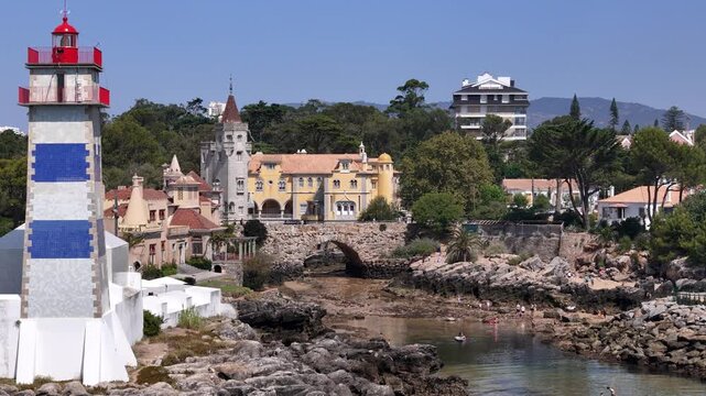 Aerial view of Farol Museu de Santa Marta lighthouse and historic buildings along the rocky coastline in Cascais, Lisboa, Portugal.