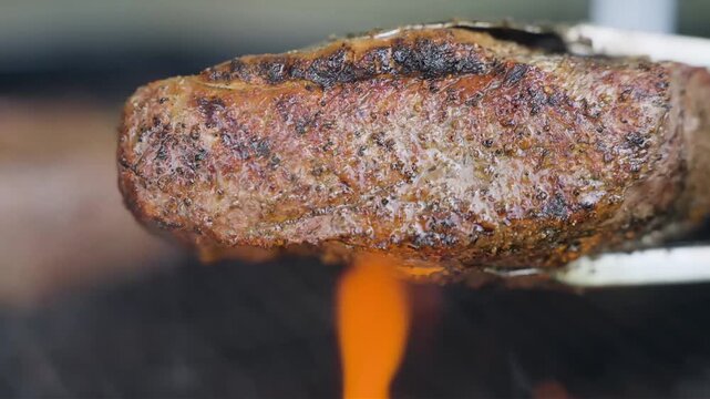 Close-up footage of steaks sizzling over an open flame grill, followed by a stylish presentation of the cooked meat. Ideal for restaurant menus, barbecue advertising, food media and culinary projects.