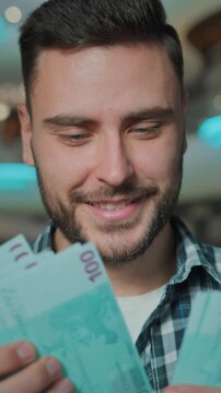 Smiling positive Caucasian business man counting money cash enjoying overspending in shop store male count savings budget black friday discounts salary buyer client businessman guy in shopping mall