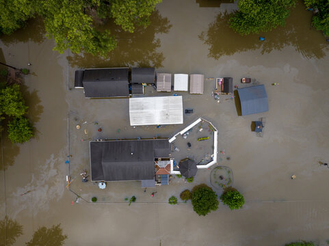 Aerial view of a flooded residential property in Broad Ripple with submerged buildings and surrounding floodwaters in Indianapolis, Indiana, United States.