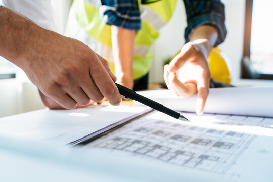 architect explaining client demand plan of construction on the table to contractor.