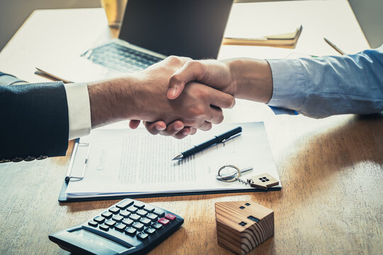 hand of client and banker shaking hands  on the meeting table after business investment budget done