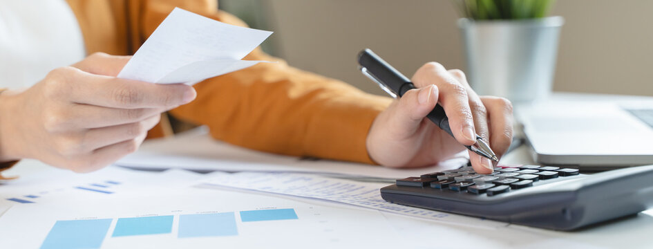 person using calculator calculating tax refund on the table