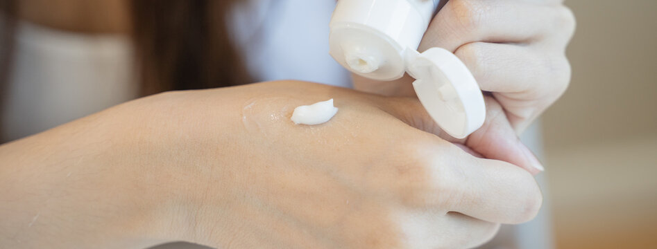 woman using moisturizer cream applying hand