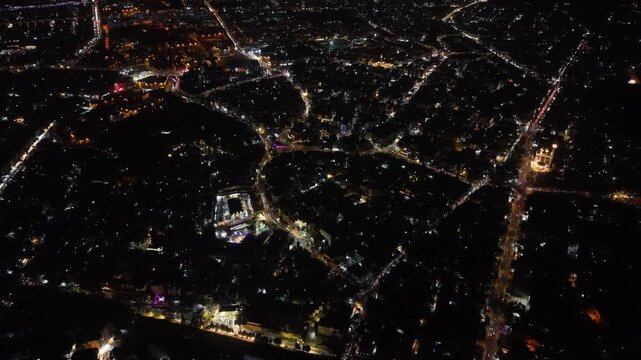 Aerial night view of an urban landscape in Syria featuring glowing city lights and illuminated streets.  Post-war Syrian cityscape and daily life at night.