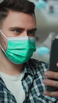 Caucasian ill sick man wearing medical mask using mobile phone app in business center unhealthy male guy with smartphone buying online scrolling social media in shopping mall quarantine coronavirus