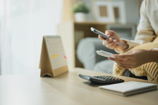 smartphone receipt calculator with expense tracking; a person reviewing a receipt by phone. smartphone guides buyer choices, receipt frames the scene, and calculator adds useful meaning.