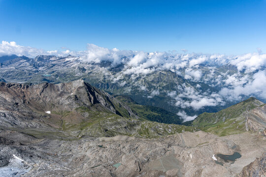 panoramic view of rugged alpine mountain peaks and rocky highlands surrounded by dramatic clouds