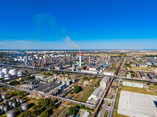 Fototapeta premium View of an industrial area with factories, smoke stacks, and storage tanks on a clear day in a developed region