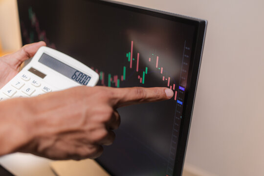Professional financial analyst reviewing stock market charts across multiple screens using a tablet, laptop and calculator to evaluate price movements, technical indicators, and investment strategies.