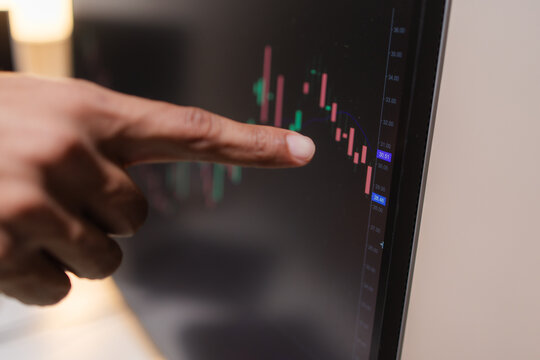 Professional financial analyst reviewing stock market charts across multiple screens using a tablet, laptop and calculator to evaluate price movements, technical indicators, and investment strategies.