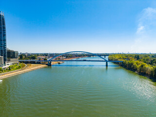 Fototapeta premium View of a river with a bridge and buildings during a clear day in an urban area