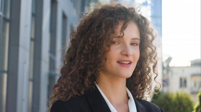 Portrait Caucasian business woman pensive dreamy look away smiling happy looking at camera in city. European thoughtful businesswoman female professional girl working pause near modern office outdoors