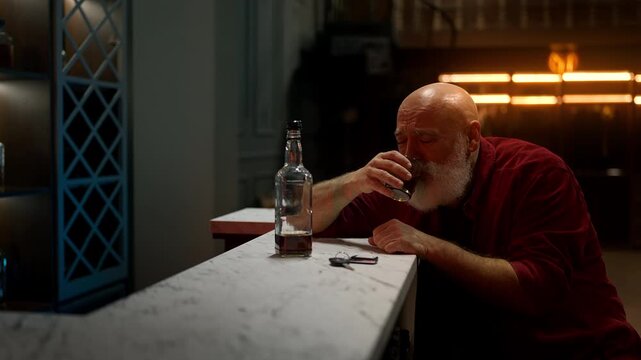 Middle-aged bearded man drinks liquor before leaving bar, drunk driving concept