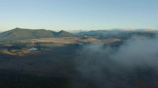 Aerial Drone Footage of Misty Mountain Valley at Sunrise with Rolling Fog and Open Plains