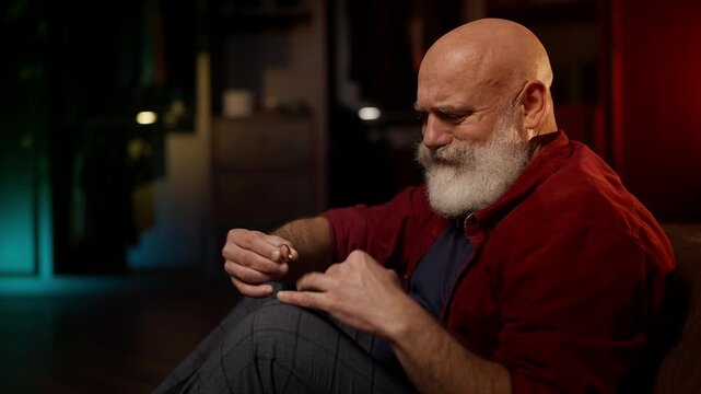 Depressed male widower holds wedding ring, grieving the loss of his beloved wife