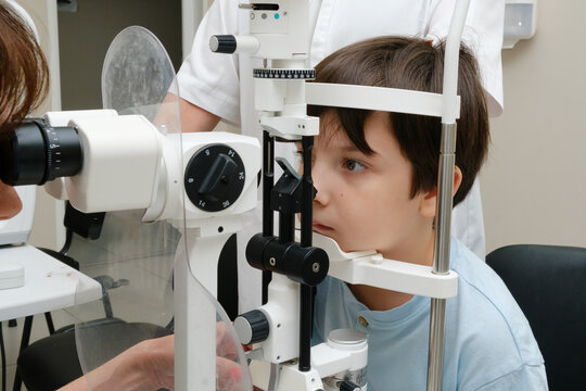 Young boy undergoing an eye examination with a slit lamp microscope in a modern ophthalmology clinic.
