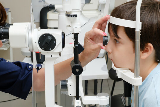 Young boy undergoing an eye examination with a slit lamp microscope in a modern ophthalmology clinic.