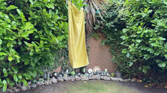 Bath Towel Hanging Outside to Dry in a Garden on a Sunny Day