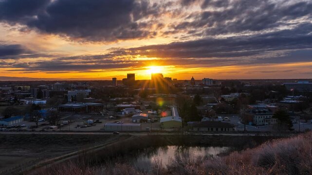 Aerial view of the downtown Boise skyline illuminated by golden hour light with a pond in the foreground, Boise, Idaho, United States.
