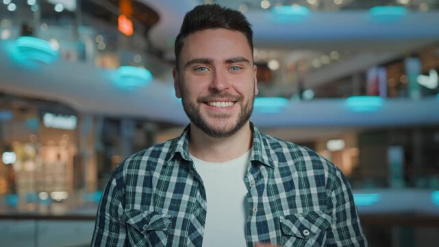 Portrait happy excited smiling Caucasian man opening shopping bag look inside satisfied with goods purchases amazed male buyer customer open package guy looking at camera smile in shop mall indoors