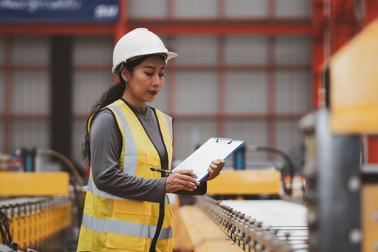 Industrial equipment inspection. Female engineer checks machine components and records maintenance data inside a modern factory. Inspection, engineer, machinery, maintenance, industry
