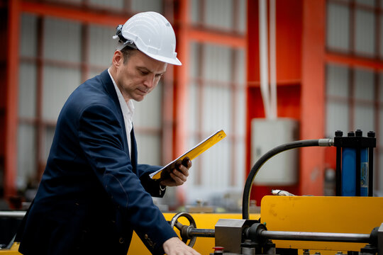 Caucasian professional Engineer factory. Engineering worker in safety hardhat at factory industrial facilities. Heavy Industry Manufacturing Factory