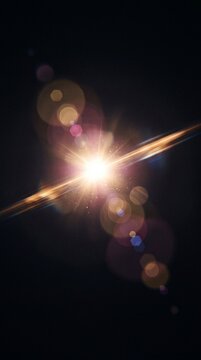 Intense golden light burst with lens flare and glowing bokeh circles creates an abstract cosmic energy effect on a black background.