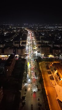 Aerial night view of an urban landscape in Syria featuring glowing city lights and illuminated streets.  Post-war Syrian cityscape and daily life at night.