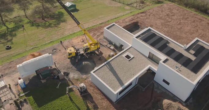 Modern flat roof house under construction on green field